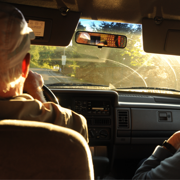 Two older adults driving in a car