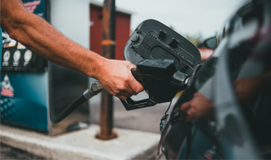 A close-up of a hand filling up their car's gas tank