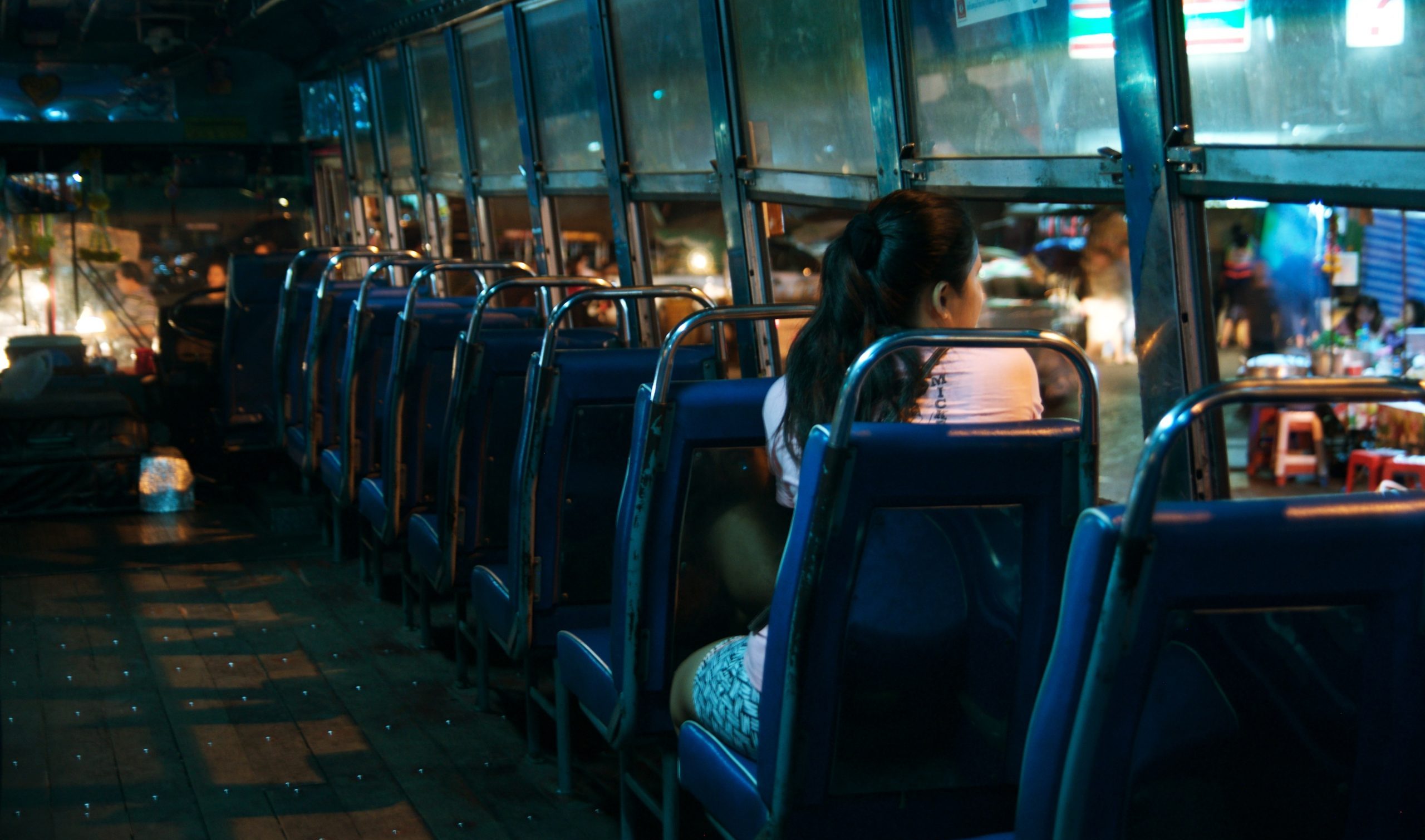 A woman rides a bus alone at night